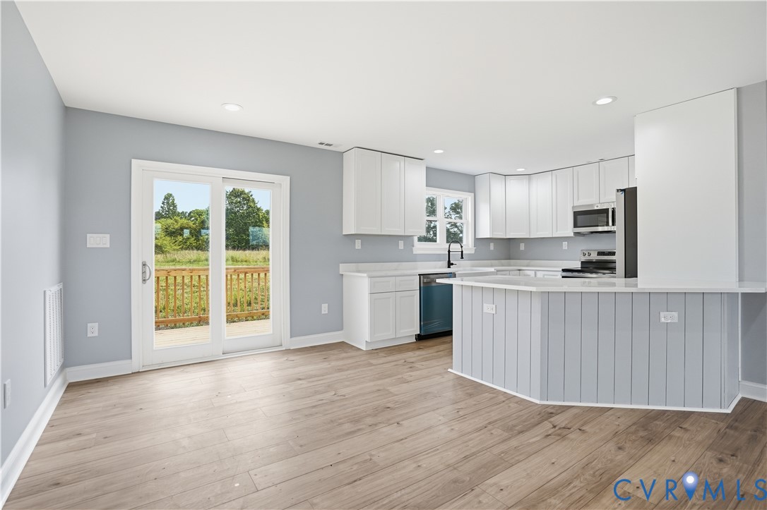 7839 King William Road Aylett, VA 23009 - Photo 14 of 38 a kitchen with stainless steel appliances granite countertop a stove a sink a refrigerator with white cabinets and wooden floor