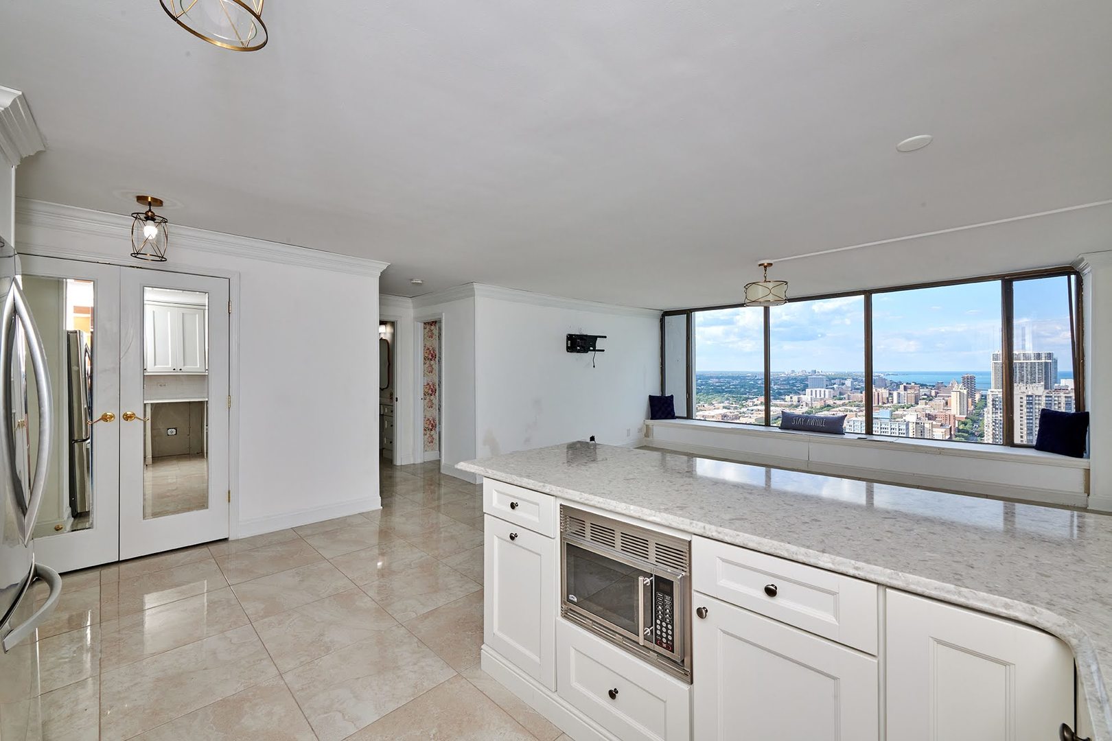 5455 North Sheridan Road, Unit 3811 Chicago, IL 60640 - Photo 6 of 35 a view with granite countertop a sink and a refrigerator in a window