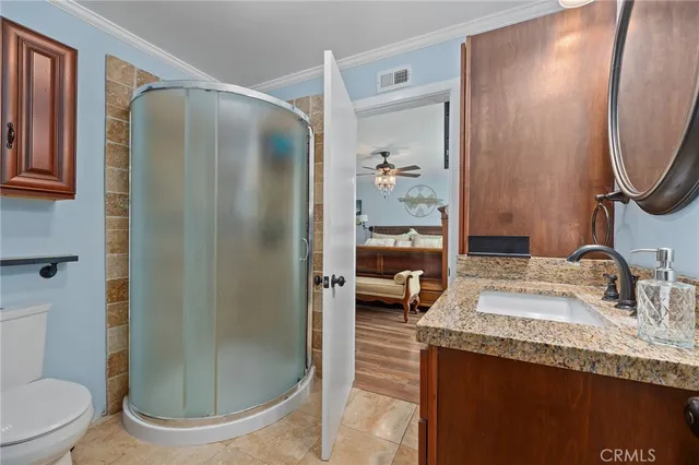 a bathroom with a granite countertop sink a toilet and shower