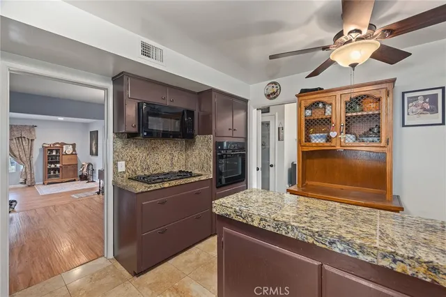 a kitchen with granite countertop a sink a counter top space cabinets stainless steel appliances and a counter top space