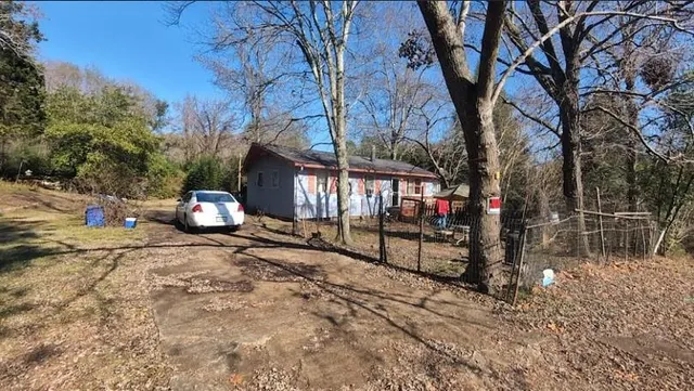 a view of backyard with a table and chairs and a large tree