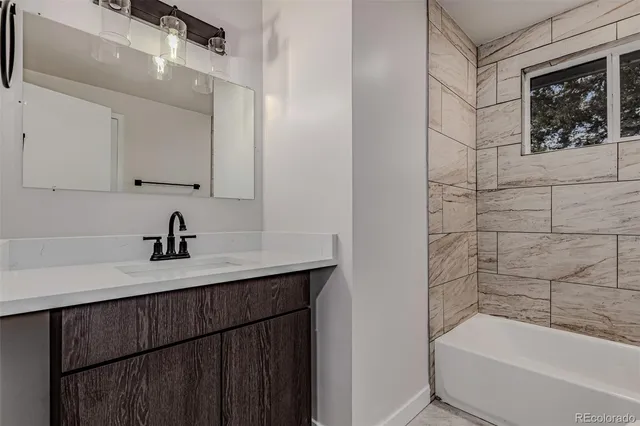 a bathroom with a bathtub sink vanity and toilet