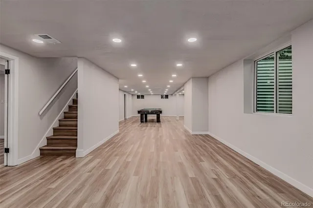 a view of a room with wooden floor staircase and a kitchen