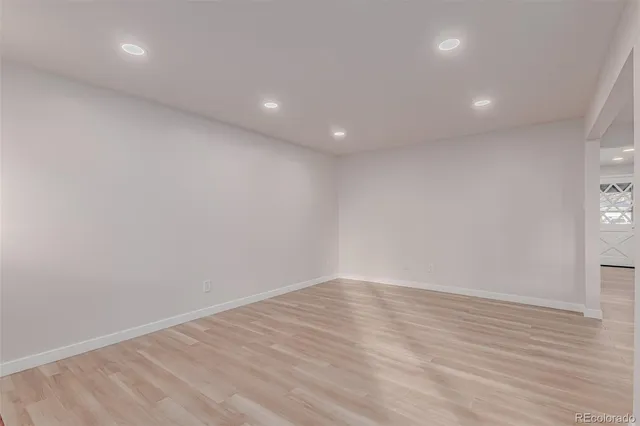an empty room with wooden floor and entrance