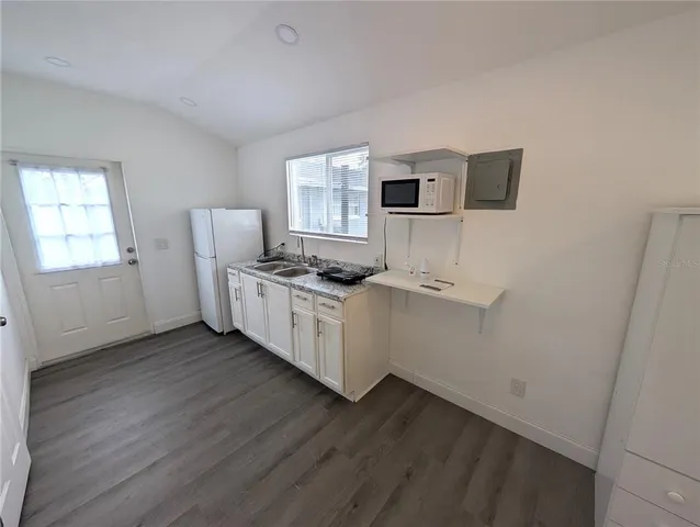 a kitchen with sink cabinets and wooden floor