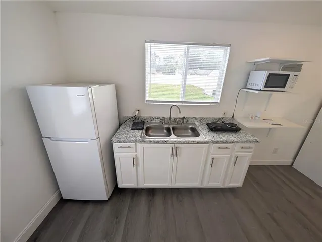 a kitchen with sink refrigerator and window