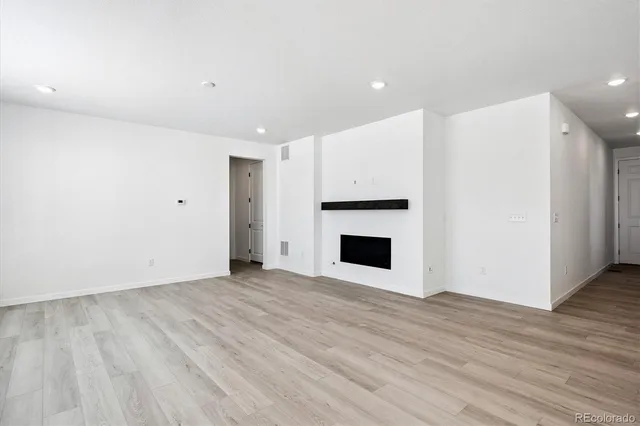 a view of empty room with wooden floor