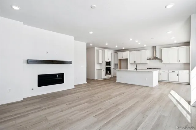 a view of kitchen with kitchen island wooden floor center island and stainless steel appliances