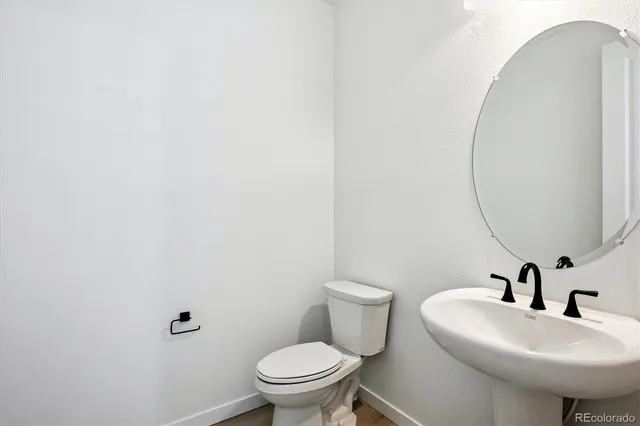 a bathroom with a sink a toilet and a mirror