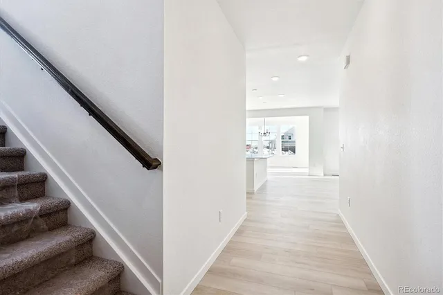 a view of a hallway with wooden floor and staircase