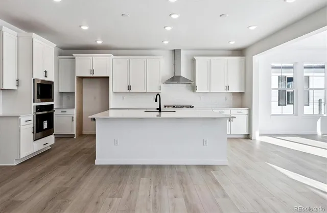 a kitchen with kitchen island white cabinets and stainless steel appliances