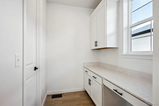 a view of a kitchen with white cabinets and a wooden floor
