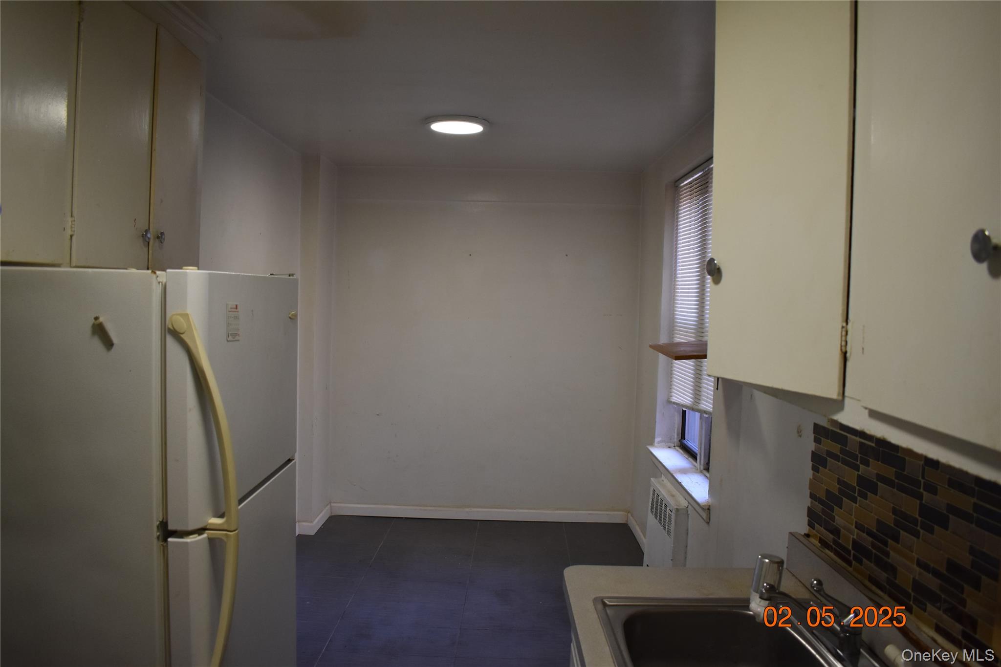 730 East 232nd Street, Unit 3G Bronx, NY 10466 - Photo 3 of 8 Kitchen featuring baseboards, a sink, freestanding refrigerator, and a healthy amount of sunlight