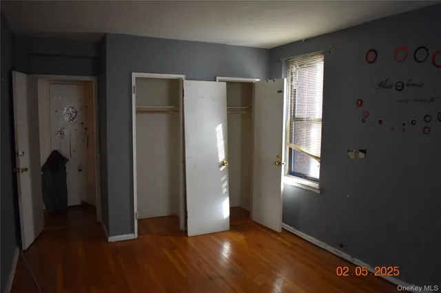a view of an empty room with closet and a window