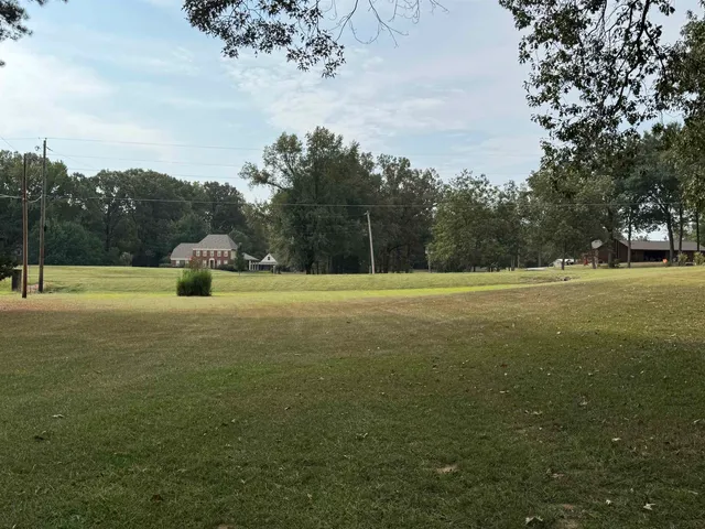 a view of outdoor space with green field and trees all around