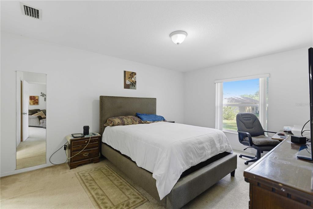 3959 Southwest 129th Street Ocala, FL 34473 - Photo 14 of 27 a bedroom with a bed and wooden floor