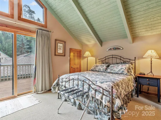 a bedroom with a bed a mirror and windows