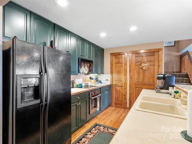 a kitchen with stainless steel appliances granite countertop a refrigerator and a sink