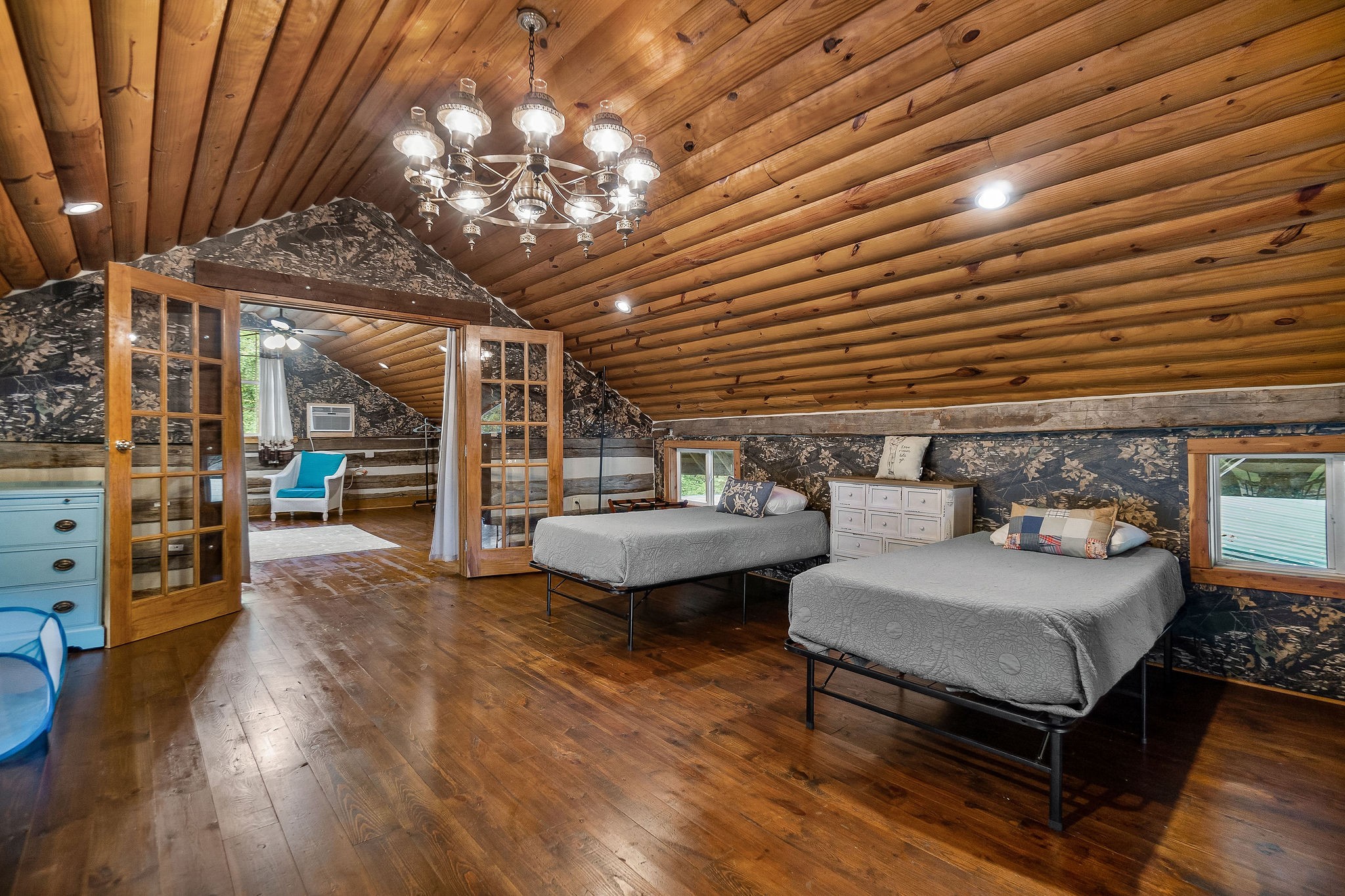 12159 Cookeville Boat Dock Road Baxter, TN 38544 - Photo 21 of 41 a spacious bedroom with a bed a chandelier and flat screen tv