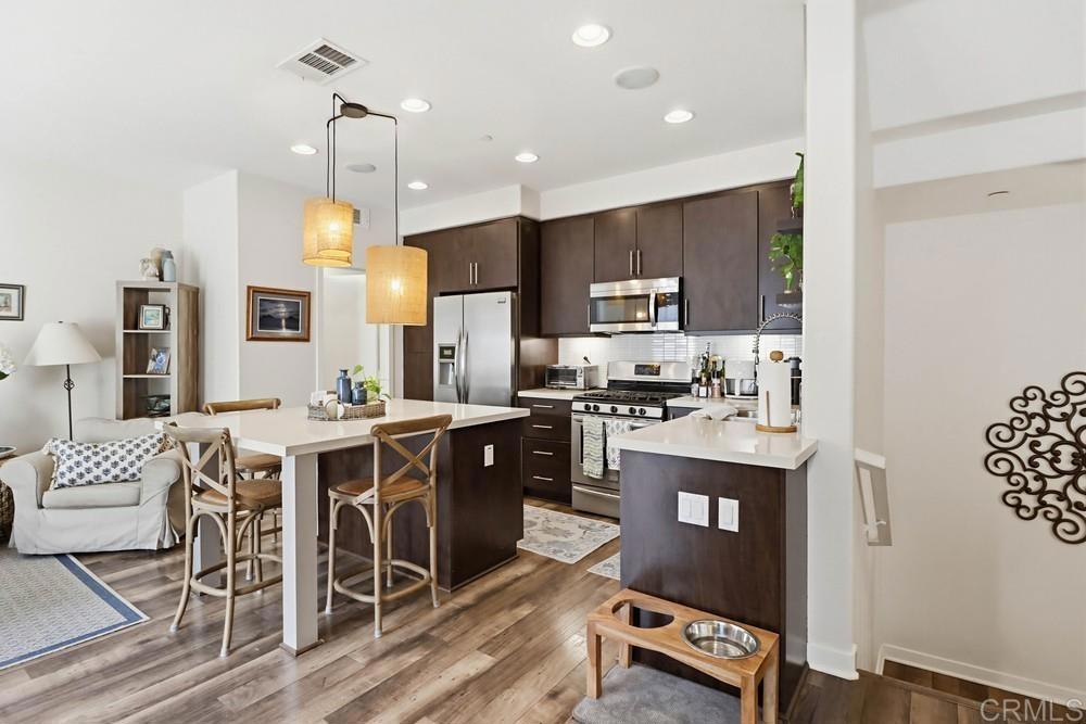 2182 Cosmo Way San Marcos, CA 92078 - Photo 6 of 34 a kitchen with stainless steel appliances kitchen island granite countertop a stove a sink a refrigerator and a cabinets