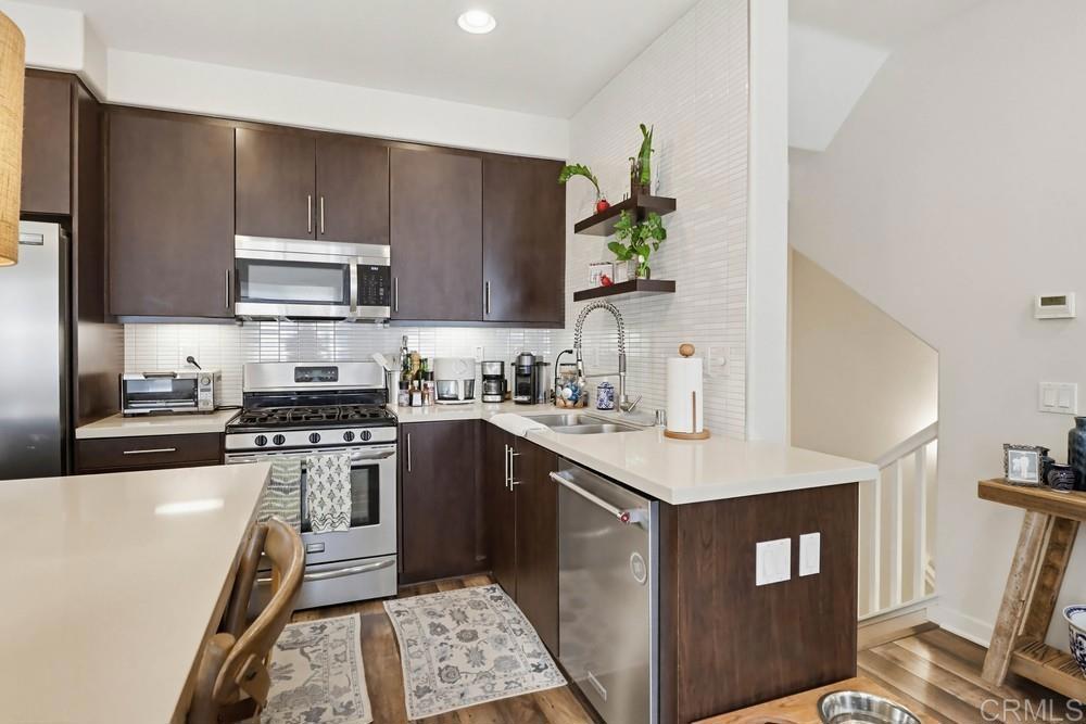 2182 Cosmo Way San Marcos, CA 92078 - Photo 7 of 34 a kitchen with stainless steel appliances a sink a stove a microwave a sink a refrigerator and cabinets