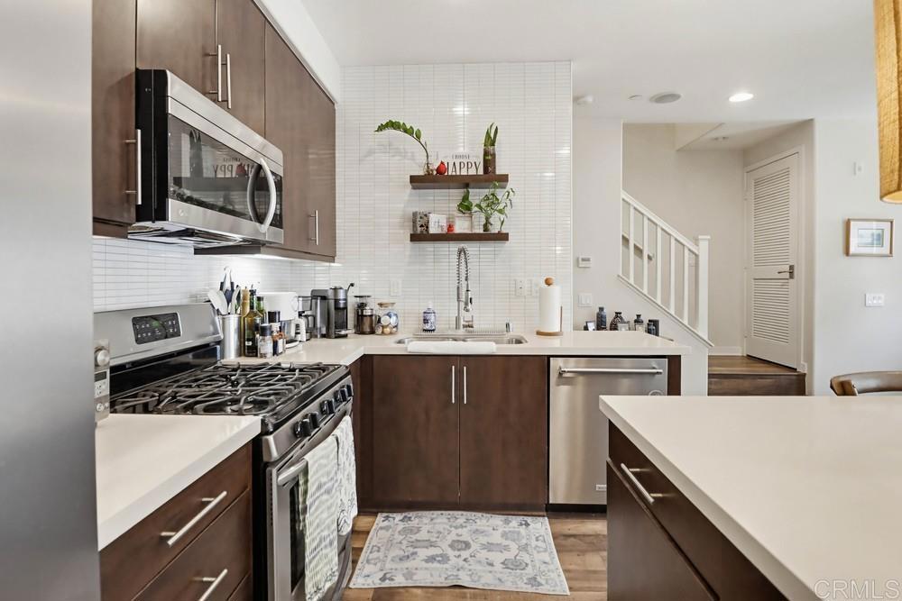 2182 Cosmo Way San Marcos, CA 92078 - Photo 8 of 34 a kitchen with stainless steel appliances a stove microwave and sink