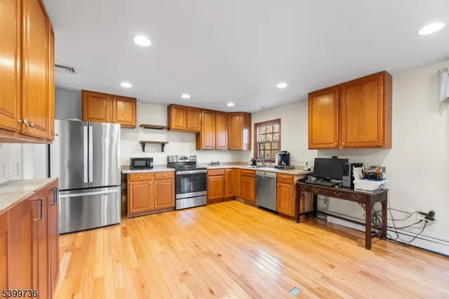 a kitchen with granite countertop a refrigerator stove top oven and sink