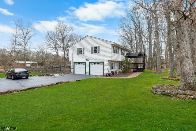 a front view of a house with a garden and trees