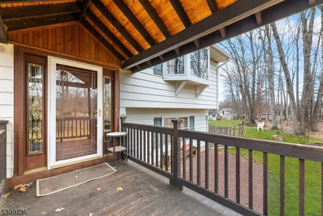 a view of a house with wooden floor next to a yard