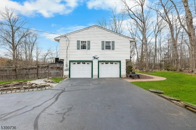 a view of a house with a yard and large tree