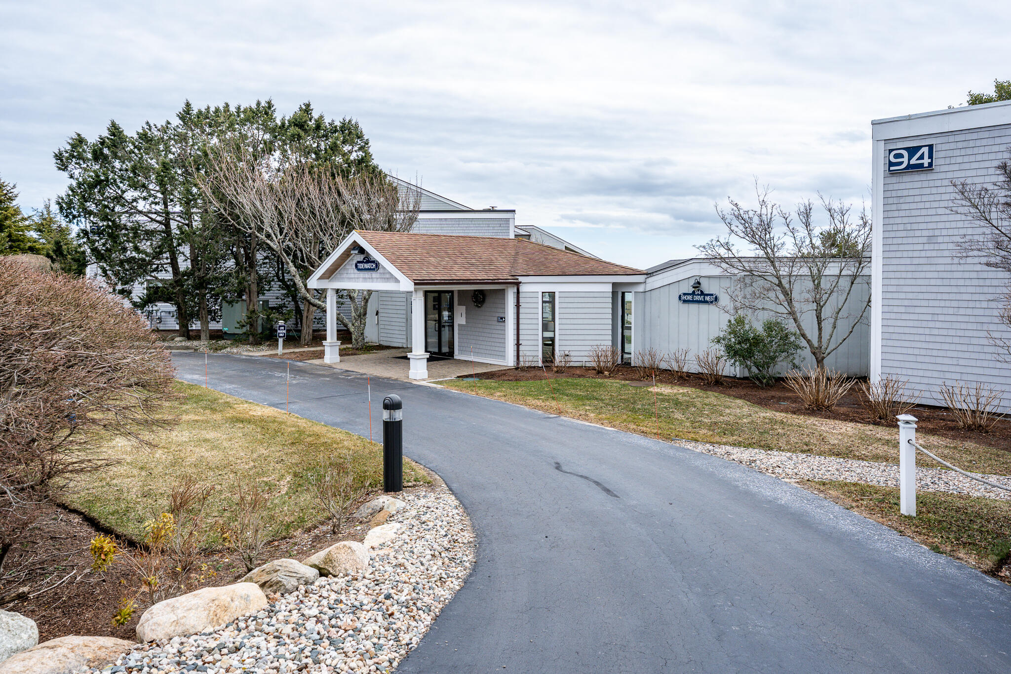94 Shore Drive West, Unit 9B Mashpee, MA 02649 - Photo 29 of 35 a house with trees in the background