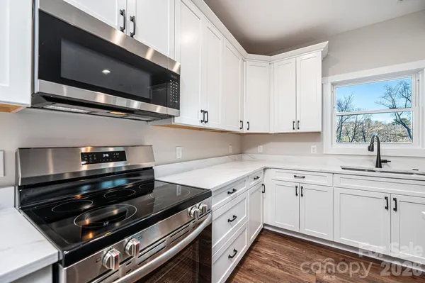 a kitchen with stainless steel appliances a sink dishwasher a stove and microwave