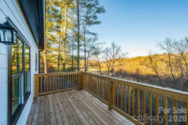 a view of a balcony with wooden floor and fence