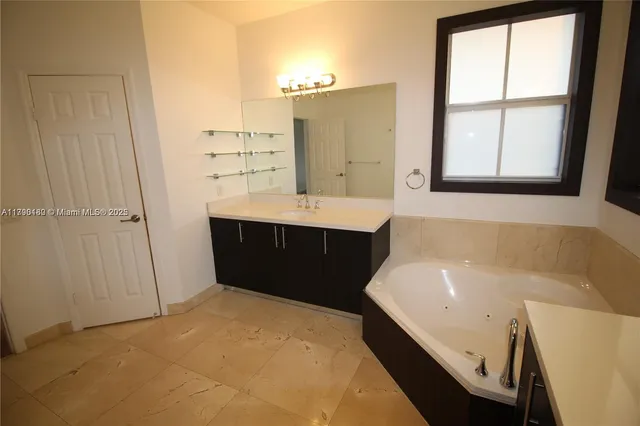 a bathroom with a tub sink and mirror