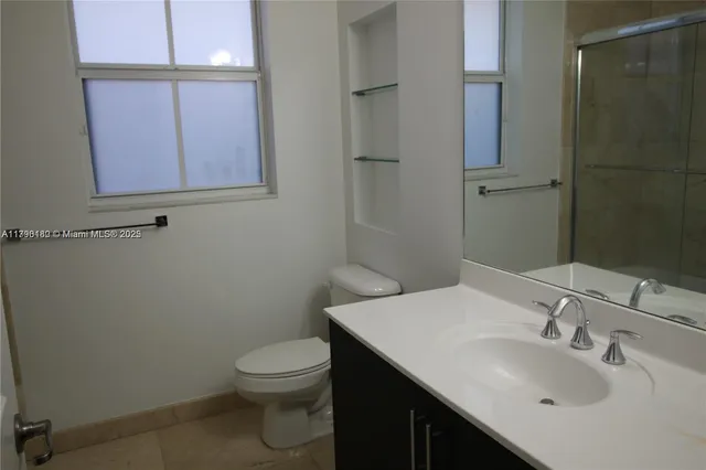 a bathroom with a sink a toilet and mirror