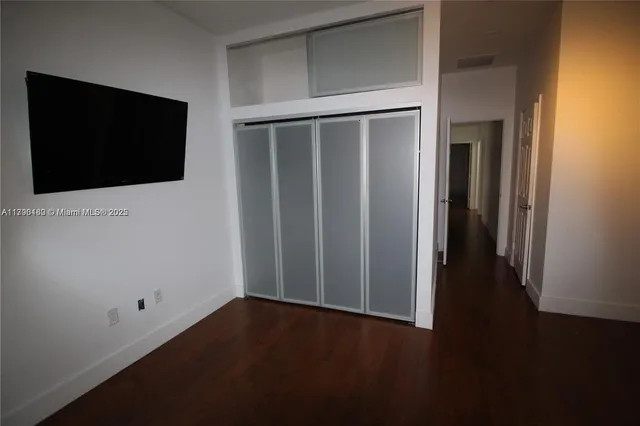 a view of a livingroom with wooden floor and cabinet