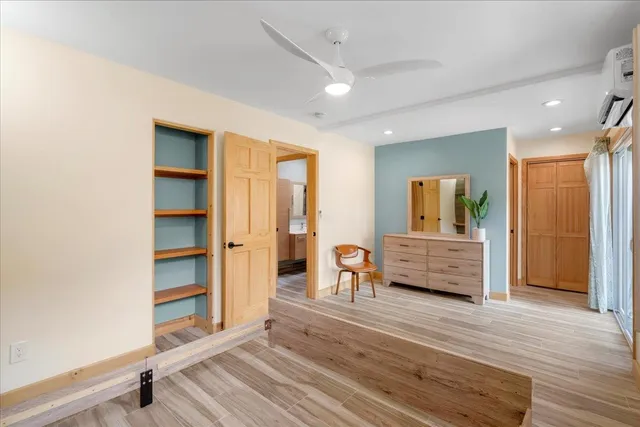 a view of a bedroom with wooden floor and furniture