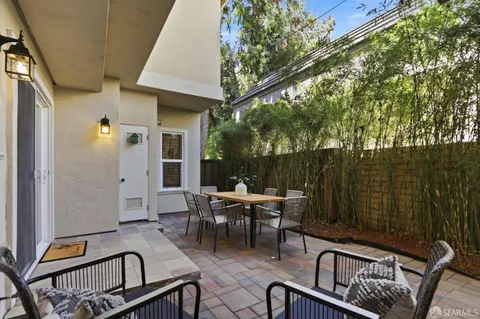 a view of a dinning table and chairs in patio of the house