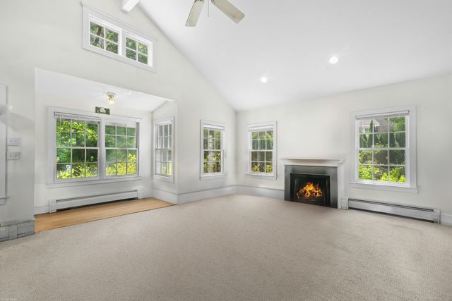 a view of an empty room with a fireplace and a window