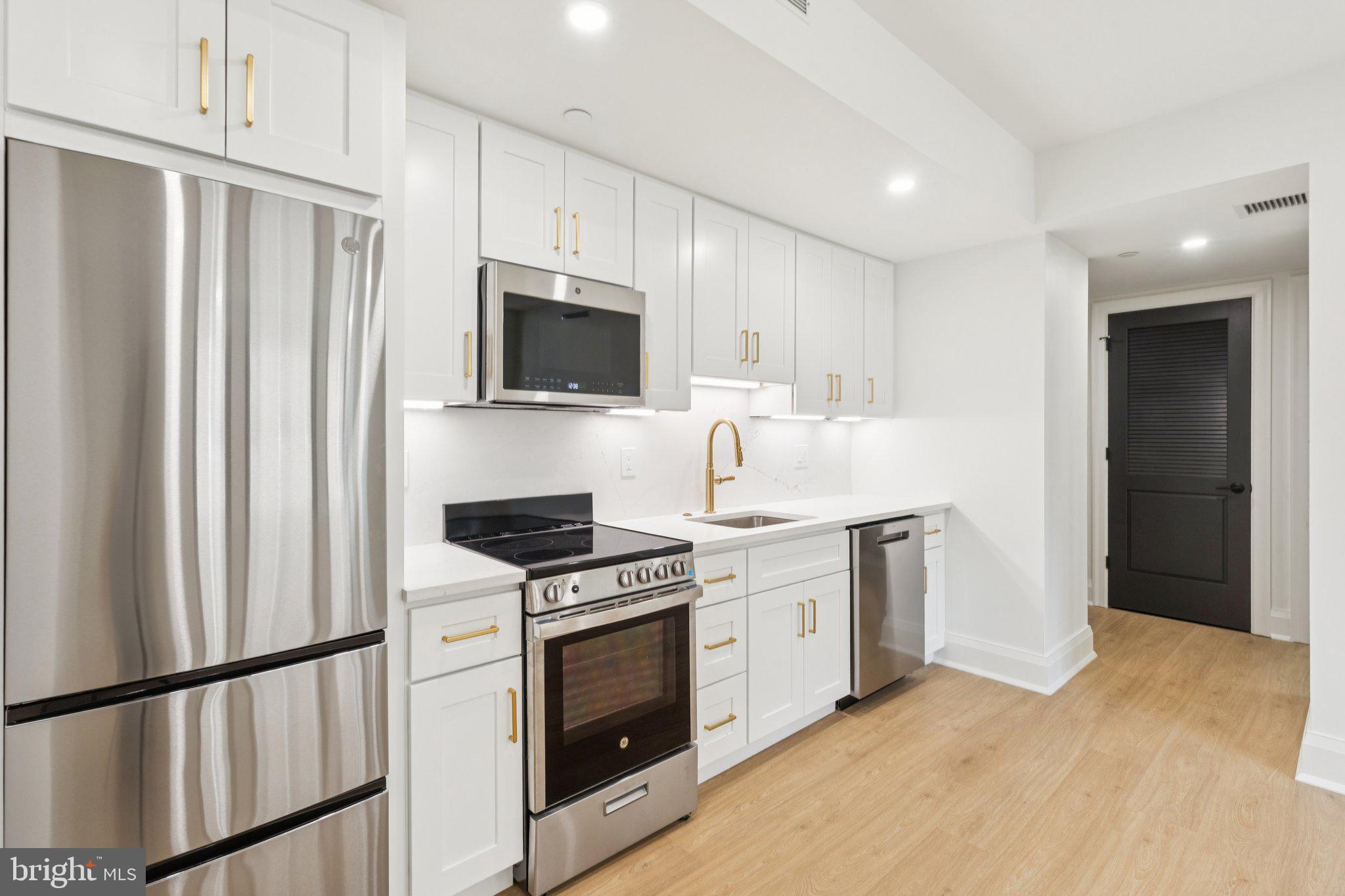135 South 19th Street, Unit 304 Philadelphia, PA 19103 - Photo 6 of 19 a kitchen with stainless steel appliances a stove a sink and a refrigerator