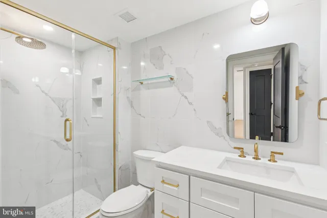 a bathroom with a sink vanity mirror and toilet