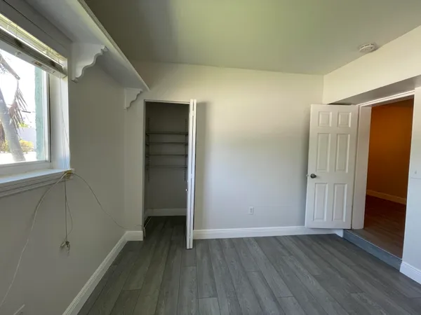 an empty room with wooden floor and closet