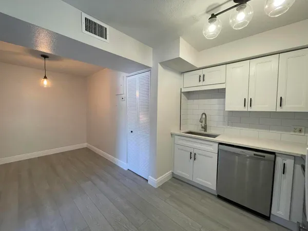 a kitchen with a sink cabinets and wooden floor