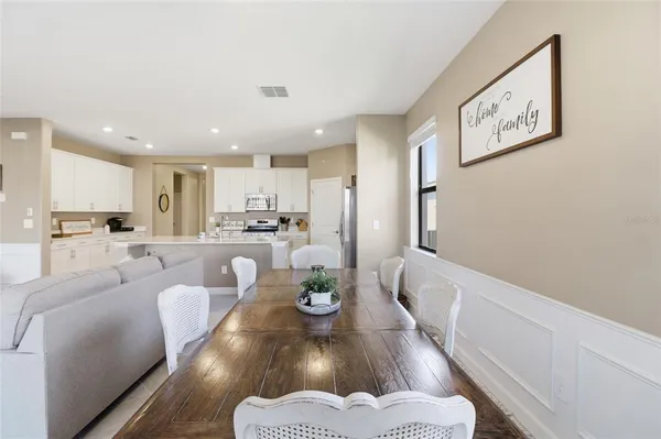 a living room with furniture kitchen view and a flat screen tv