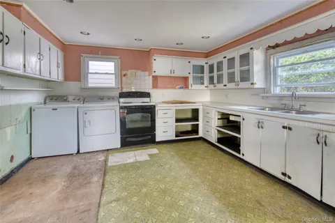 a kitchen with a stove sink and cabinets