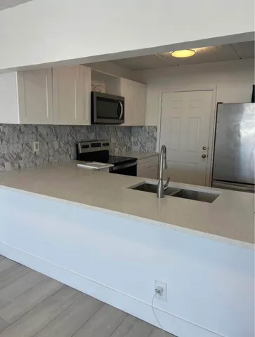 a kitchen with granite countertop a sink and a stove top oven