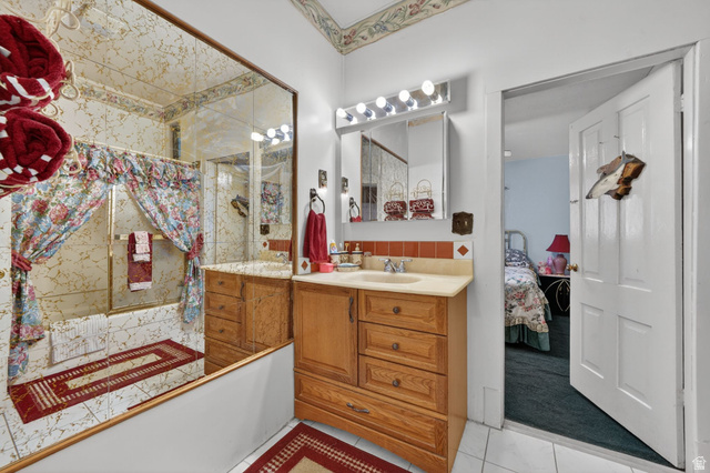 977 23rd Street Ogden, UT 84401 - Photo 9 of 29 Full bathroom with vanity, connected bathroom, backsplash, and light tile patterned floors