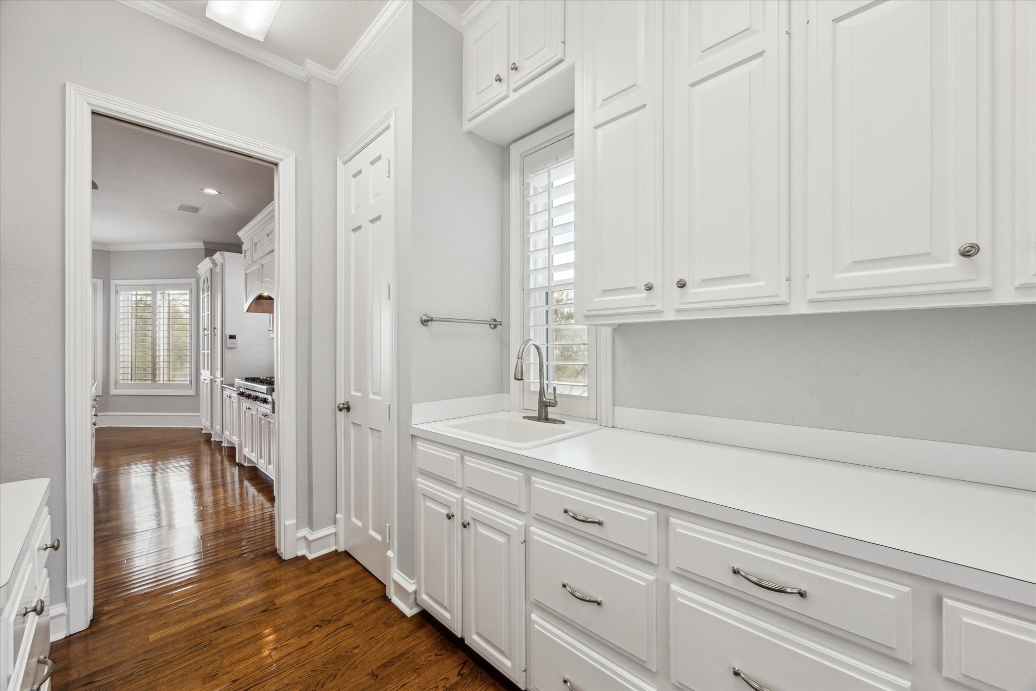 1406 Spring Cress Lane Seabrook, TX 77586 - Photo 17 of 50 The main laundry room is at the rear of the kitchen. Features include a pantry closet, drop sink, double folding shelves, upper cabinet storage and lower cabinet and drawer storage.