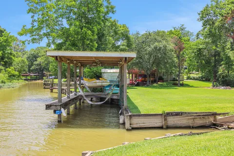 a view of swimming pool with lawn chairs wooden floor and fence