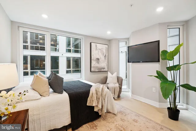 a living room with furniture a flat screen tv and a potted plant